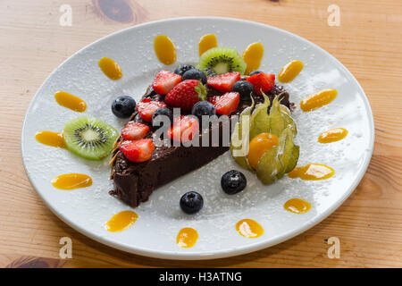 "Mort par maison Jardin' chocolat gâteau décoré avec des fruits et purées de fruits Banque D'Images