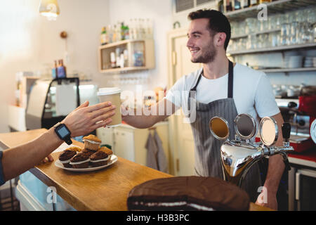 Heureux de servir le café barista cafe au client Banque D'Images