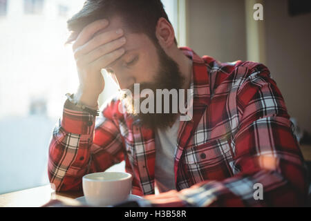 Client malheureux assis au café Banque D'Images