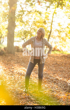 Young woman standing with hands on hip in forest Banque D'Images