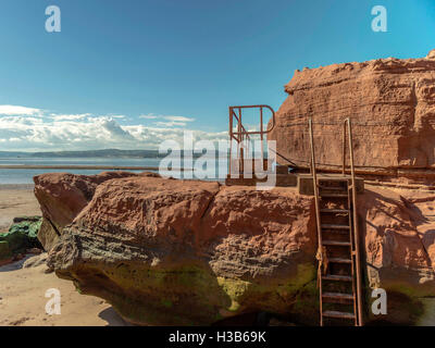 Formations rocheuses rustique visibles à marée basse et la rouille metal l'intercirculation à Orcome Point près de la ville balnéaire de Exmouth, Devon. Banque D'Images