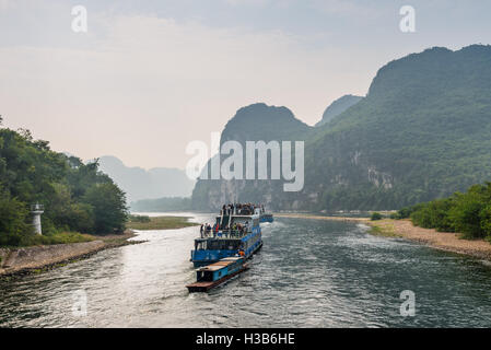 Un des bateaux de tourisme rempli de touristes voyages la magnifique route panoramique le long de la rivière Li Banque D'Images