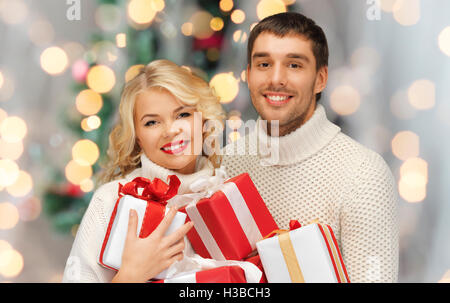 Couple heureux dans pulls holding christmas gifts Banque D'Images