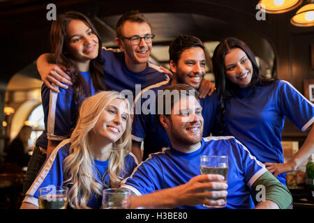 Les fans de football ou des amis avec de la bière au bar des sports Banque D'Images