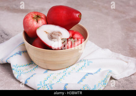 Fruits tropicaux Acmella oleracea (mal de dents, de l'usine, paracress electric daisy, le jambu) dans bol en bois sur la table de marbre. Banque D'Images