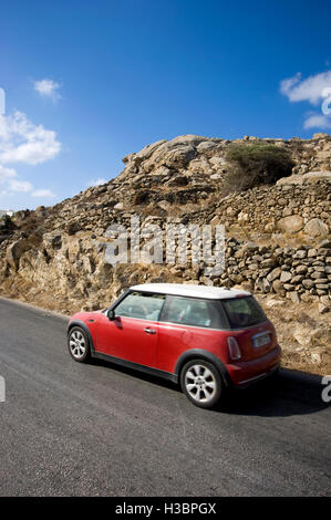 Voiture Mini Cooper de la conduite sur route sur l'île de Mykonos en Grèce Banque D'Images