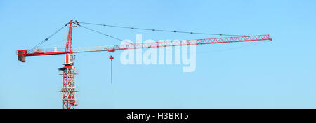 Bâtiment blanc et rouge grue a tour contre un ciel bleu. Grue à flèche Banque D'Images