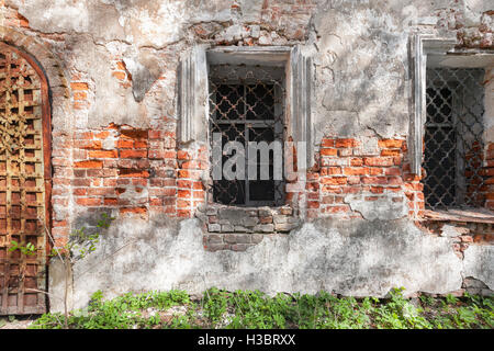 Fenêtre vintage avec des barres de fer sur le mur d'un temple abandonné Banque D'Images