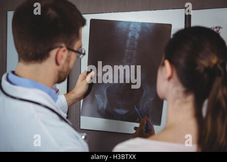 Physiothérapeute expliquant à rayons x de la colonne vertébrale pour femme Banque D'Images