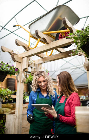 Deux femmes fleuristes using digital tablet Banque D'Images