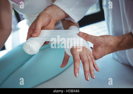 Thérapeute mâle femelle mettre bandage sur la main du patient Banque D'Images