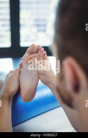 Physiothérapeute mâles donnant massage des pieds pour femme Banque D'Images