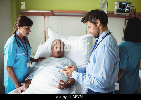 Médecin Homme montrant un rapport à senior patient on digital tablet Banque D'Images