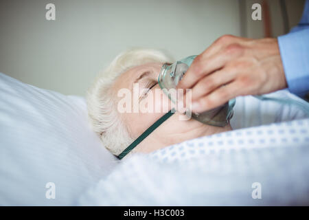 Doctor putting oxygen mask on patient Banque D'Images