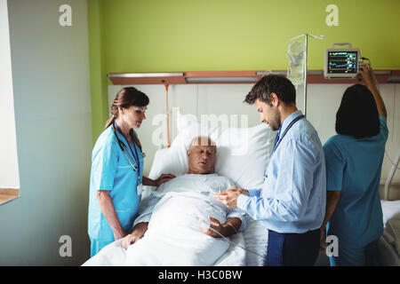 Médecin Homme montrant un rapport à senior patient on digital tablet Banque D'Images