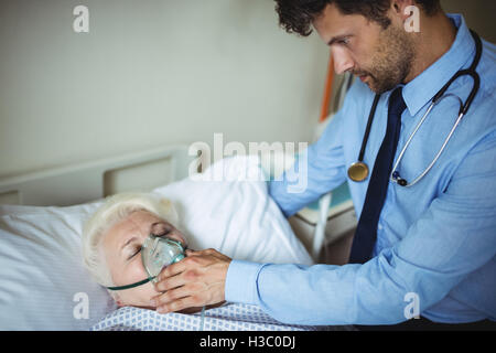 Doctor putting oxygen mask on patient Banque D'Images