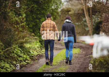 Couple en train de marcher sur un chemin de terre Banque D'Images