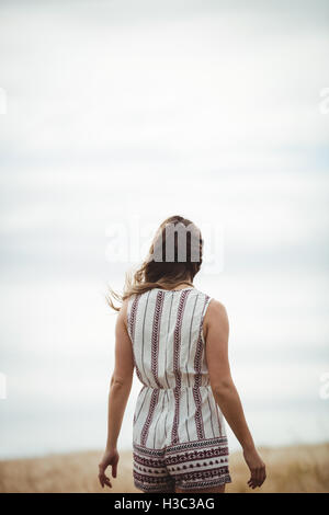 Vue arrière de la femme marche à travers champ de blé Banque D'Images