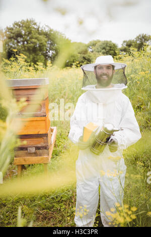 Portrait d'apiculteur holding bee fumeur Banque D'Images