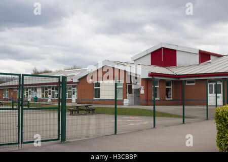 Haut fil clôtures de sécurité entoure l'aire de jeux à l'école primaire de Queensbridge, Saint Germain rue, Farnworth. Banque D'Images