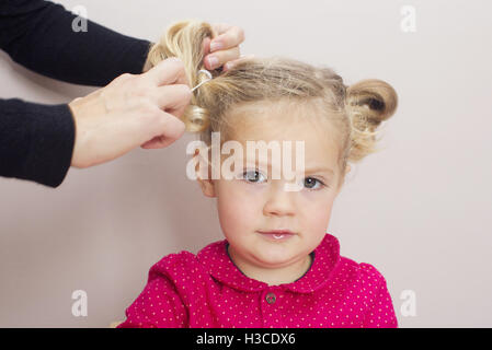 Petite fille ayant organisé ses cheveux en amorces Banque D'Images