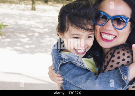 Mère et fille embracing outdoors, portrait Banque D'Images