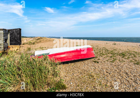 Rouge tournée vers le bateau à rames sur la plage de galets à Dunwich, un village dans le Suffolk coastal ergion, East Anglia, Royaume-Uni Banque D'Images