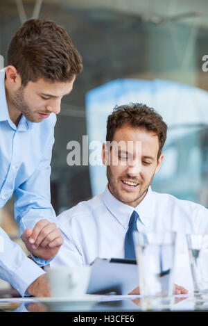 Businessman showing proposition d'collègue on digital tablet Banque D'Images