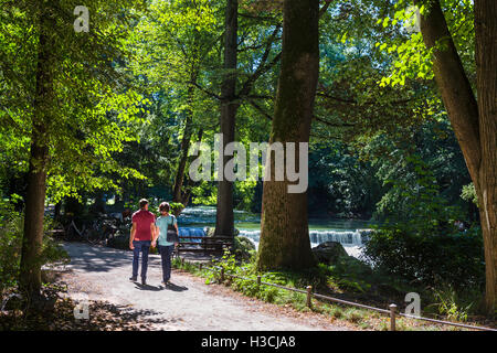 Couple par l'Eisbach dans l'Englischer Garten, Munich, Bavière, Allemagne Banque D'Images