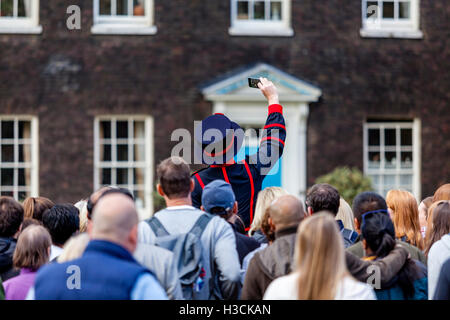 Un Beefeater (Yeoman de la garde) emmène un groupe avec un touriste Selfies's Phone au cours d'une visite à la Tour de Londres, London, UK Banque D'Images