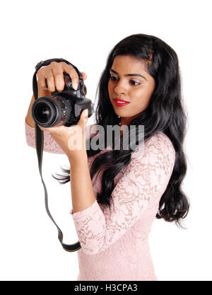 Une belle jeune femme indienne à prendre des photos avec une caméra DLS, isolée pour fond blanc. Banque D'Images