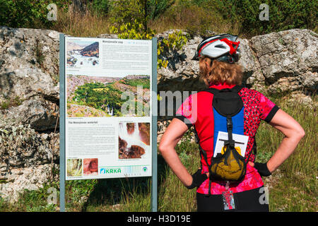 Panneau d'interprétation de la lecture d'un visiteur à Manojlovac Falls, parc national de Krka, Dalmatie, Croatie Banque D'Images