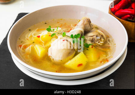 Soupe de poulet frais avec des cuisses de poulet, légumes, nouilles et origan vert herbe Banque D'Images