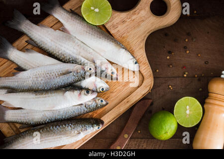 Fruits de mer frais poissons mulet avec de la chaux et d'épices sur une vieille table en bois. Vue de dessus Banque D'Images