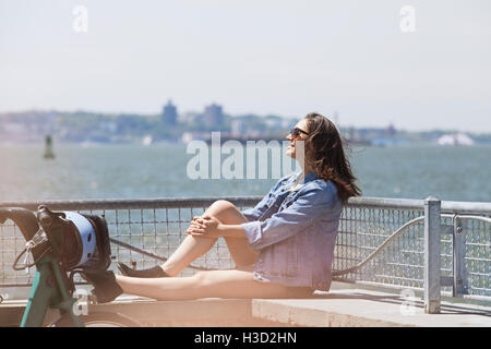 Vue latérale du woman relaxing on mur de retenue au point d'observation Banque D'Images