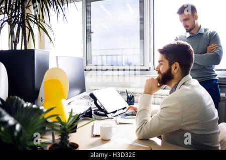 hommes d'affaires utilisant l'ordinateur de bureau dans le bureau créatif Banque D'Images