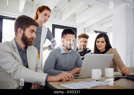 Creative business people using laptop in office Banque D'Images