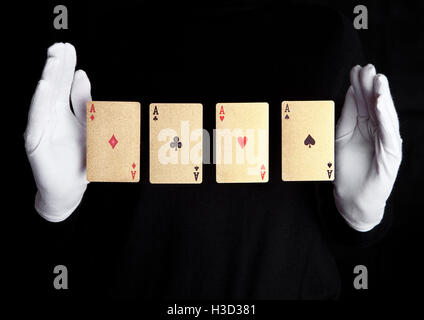 Les cartes à jouer astuce avec ace mains avec des gants sur fond noir Banque D'Images