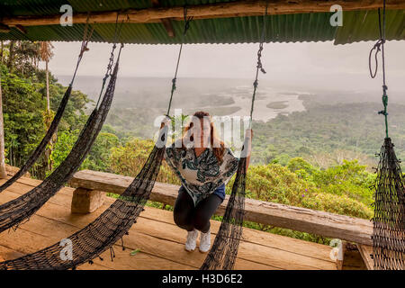 Femme blonde européenne constatant une partie du bassin amazonien à partir d'un point élevé d'observation, de l'Équateur, en Amérique du Sud Banque D'Images