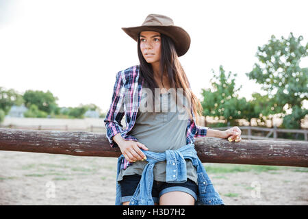 Portrait de belle jeune femme cowgirl dans chapeau et chemise à carreaux Banque D'Images