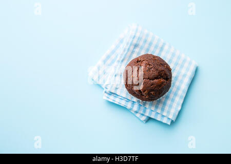 Le muffin au chocolat savoureux sur bleu serviette. Vue d'en haut. Banque D'Images