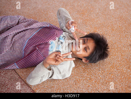 Enfant de la rue, sur le quai Sisowath de Phnom Penh, Cambodge. Banque D'Images