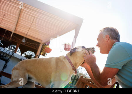 Smiling senior man de caresser un chien. Banque D'Images