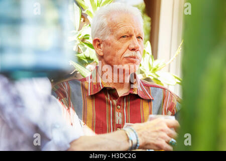 Man avec moustache assis à l'extérieur. Banque D'Images
