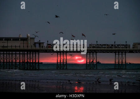 Worthing, Sussex, UK. 7 octobre, 2016. 07/10/2016 bord de mer, à Worthing. Un aperçu d'un rouge lumineux soleil, il s'élève au-dessus de l'horizon et est immédiatement englouti dans les nuages .Photo par : Julie Edwards/Alamy Live News Banque D'Images