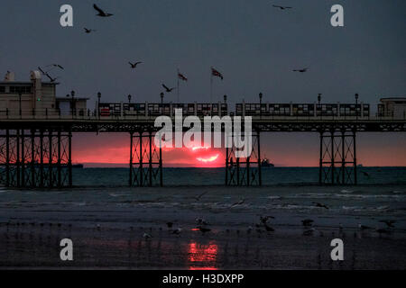 Worthing, Sussex, UK. 7 octobre, 2016. 07/10/2016 bord de mer, à Worthing. Un aperçu d'un rouge lumineux soleil, il s'élève au-dessus de l'horizon et est immédiatement englouti dans les nuages .Photo par : Julie Edwards/Alamy Live News Banque D'Images