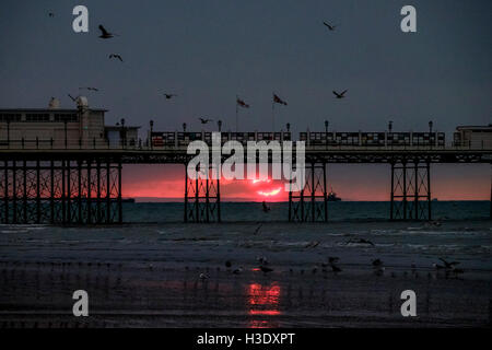 Worthing, Sussex, UK. 7 octobre, 2016. 07/10/2016 bord de mer, à Worthing. Un aperçu d'un rouge lumineux soleil, il s'élève au-dessus de l'horizon et est immédiatement englouti dans les nuages .Photo par : Julie Edwards/Alamy Live News Banque D'Images