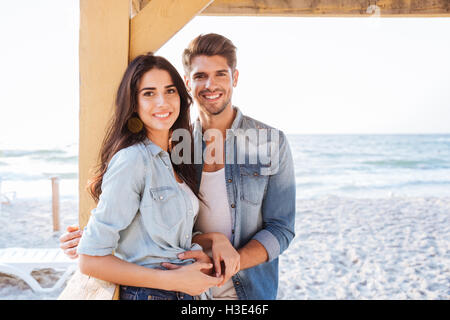 Young smiling couple amoureux se tenant ensemble à la plage Banque D'Images