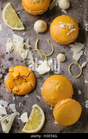 Ensemble et broken orange citron macarons fait maison avec des morceaux de chocolat blanc et le sucre et le zeste d'agrumes plus vieux texture métal Banque D'Images