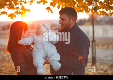 Happy Family walking outdoors, père, mère et bébé mignon Banque D'Images